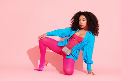 Photo of Fashionable portrait of beautiful Brazilian woman in stylish outfit on pink background