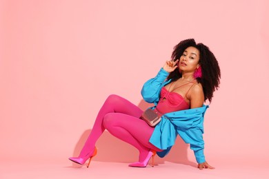 Photo of Fashionable portrait of beautiful Brazilian woman in stylish outfit on pink background