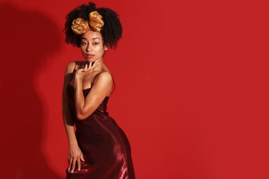 Photo of Fashionable portrait of beautiful Brazilian woman in stylish outfit on red background. Space for text