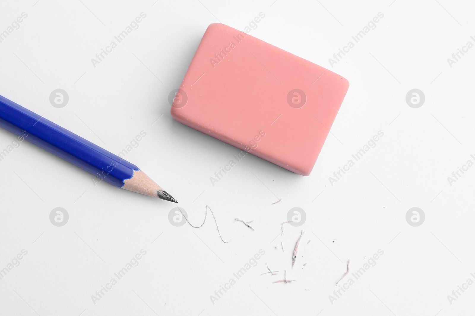 Pencil, eraser, doodle and scraps on white background, flat lay Photo of Pencil, eraser, doodle and scraps on white background, flat lay