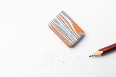 Photo of Pencil, eraser and scraps on white background, flat lay. Space for text