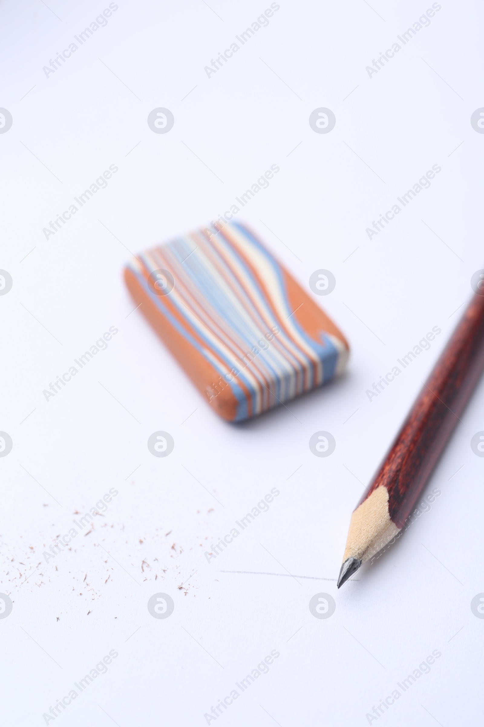 Pencil, eraser and scraps on white background, selective focus Photo of Pencil, eraser and scraps on white background, selective focus