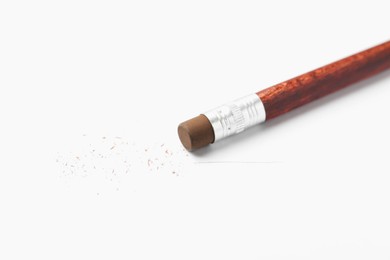 Photo of Pencil with eraser and scraps on white background, closeup