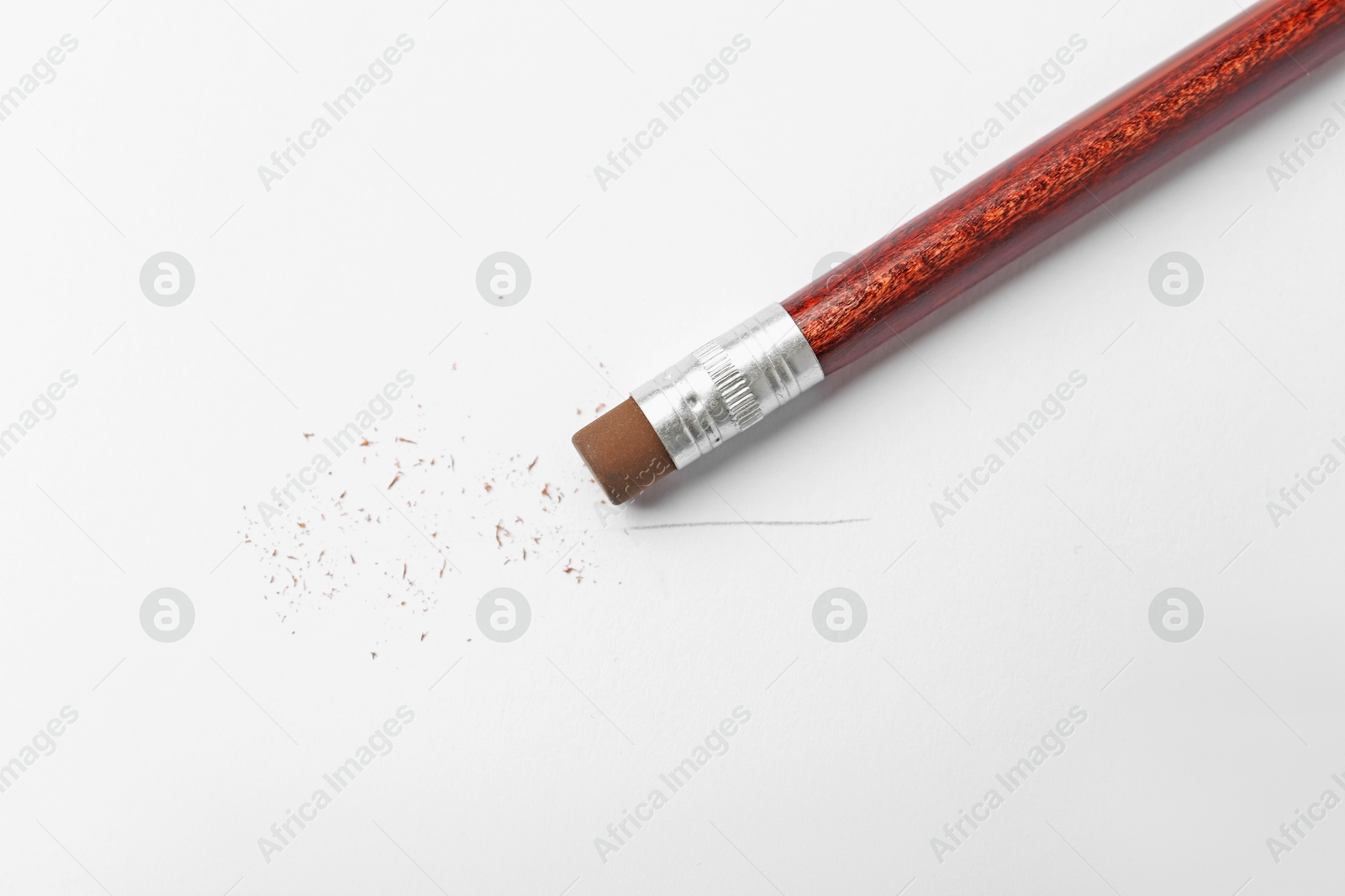 Photo of Pencil with eraser and scraps on white background, top view