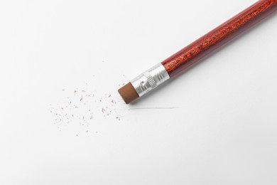 Photo of Pencil with eraser and scraps on white background, top view