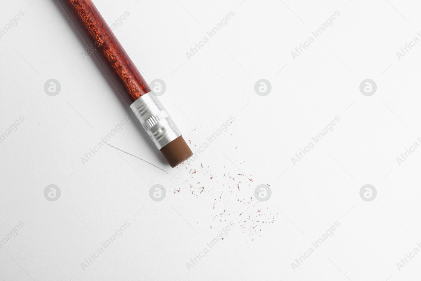 Pencil with eraser and scraps on white background, top view Photo of Pencil with eraser and scraps on white background, top view