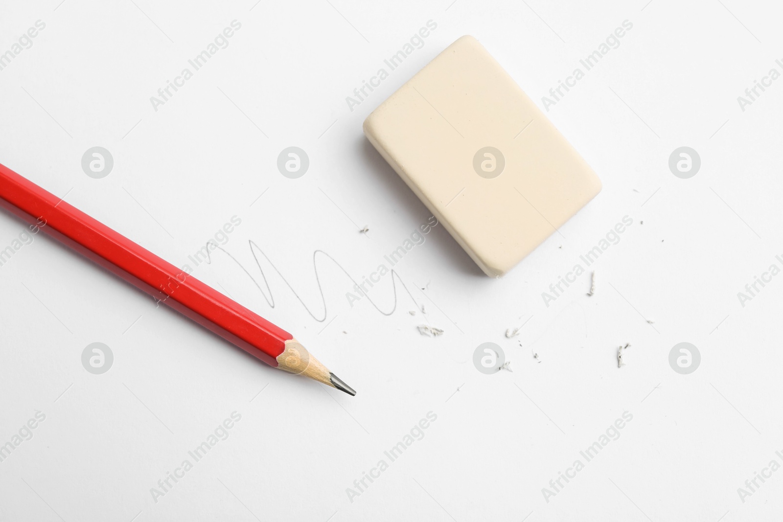 Photo of Pencil, eraser, doodle and scraps on white background, flat lay
