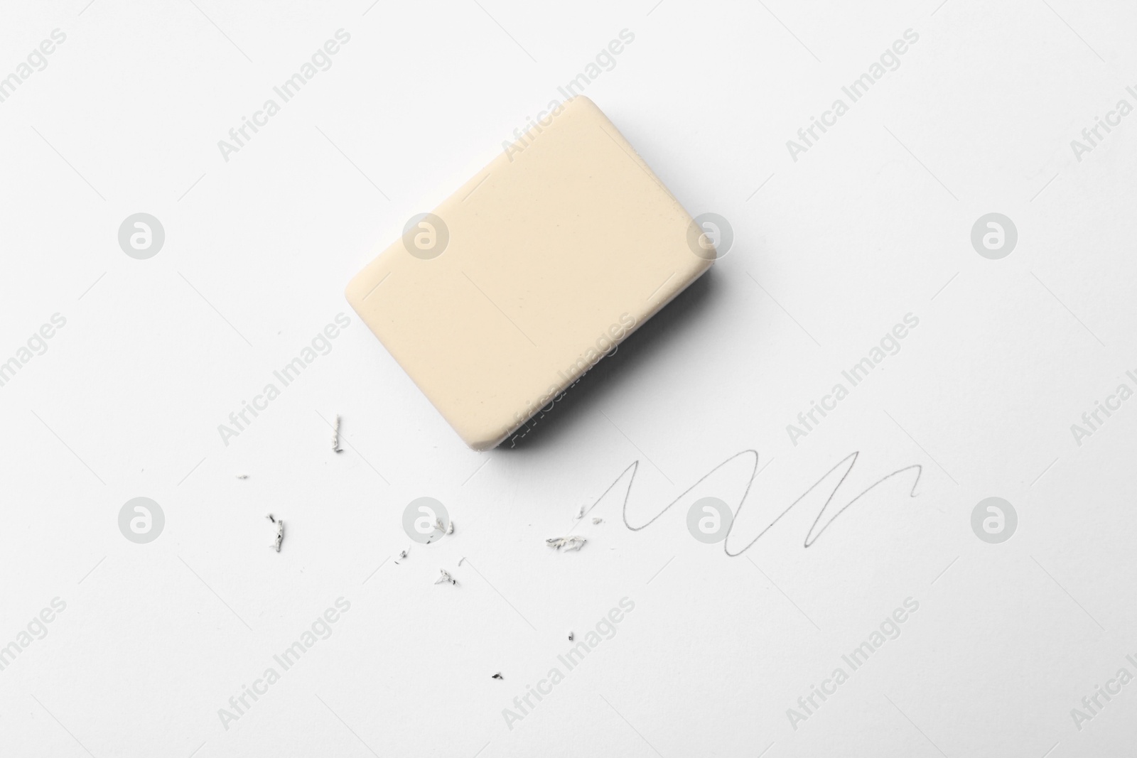Photo of Eraser, doodle and scraps on white background, top view
