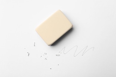 Photo of Eraser, doodle and scraps on white background, top view