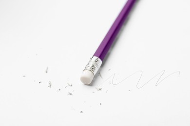 Photo of Pencil with eraser, doodle and scraps on white background, closeup