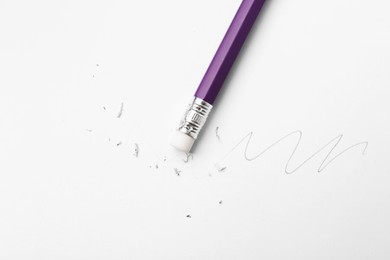 Photo of Pencil with eraser, doodle and scraps on white background, top view