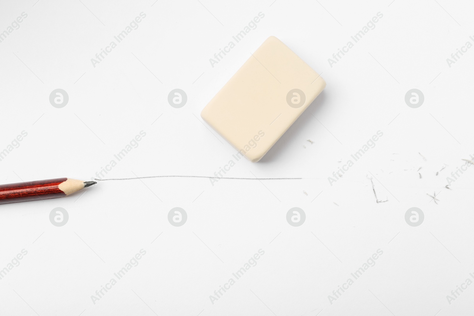 Pencil, eraser, line and scraps on white paper, flat lay Photo of Pencil, eraser, line and scraps on white paper, flat lay