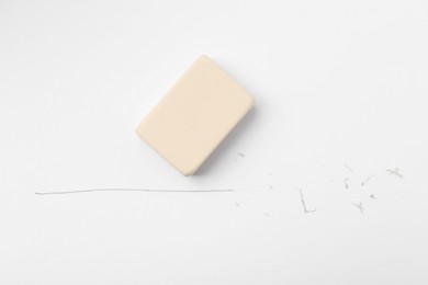 Photo of Eraser, line and scraps on white paper, top view