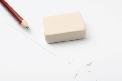 Photo of Pencil, eraser, line and scraps on white paper, selective focus