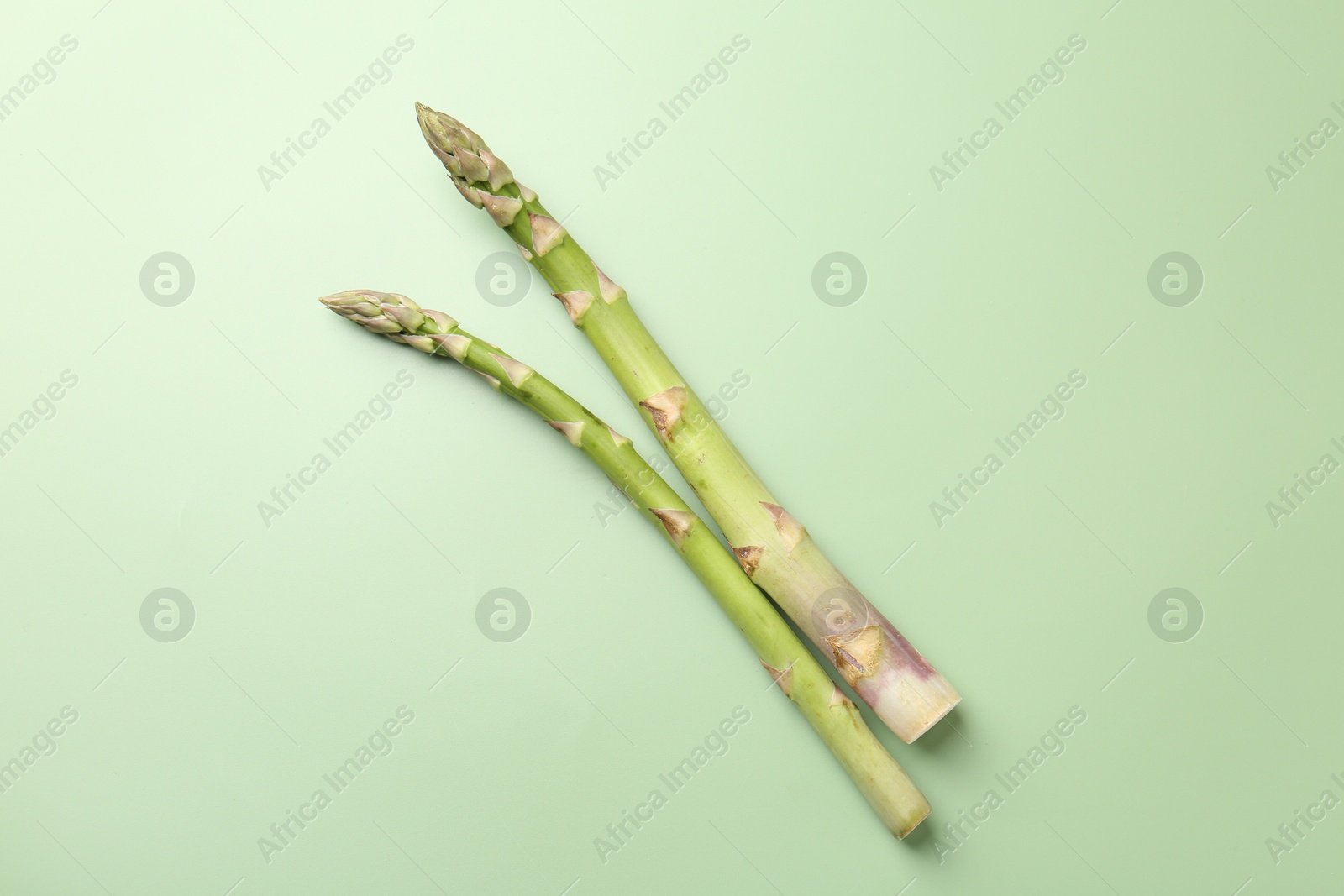 Fresh ripe raw asparagus on green background, top view Photo of Fresh ripe raw asparagus on green background, top view
