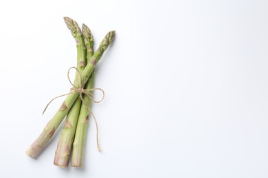 Photo of Fresh ripe raw asparagus on white background, top view. Space for text