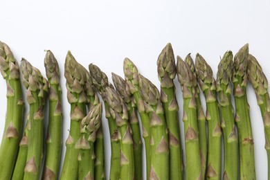 Photo of Fresh ripe raw asparagus on white background, flat lay