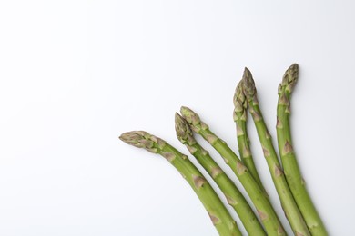 Photo of Fresh ripe raw asparagus on white background, flat lay. Space for text