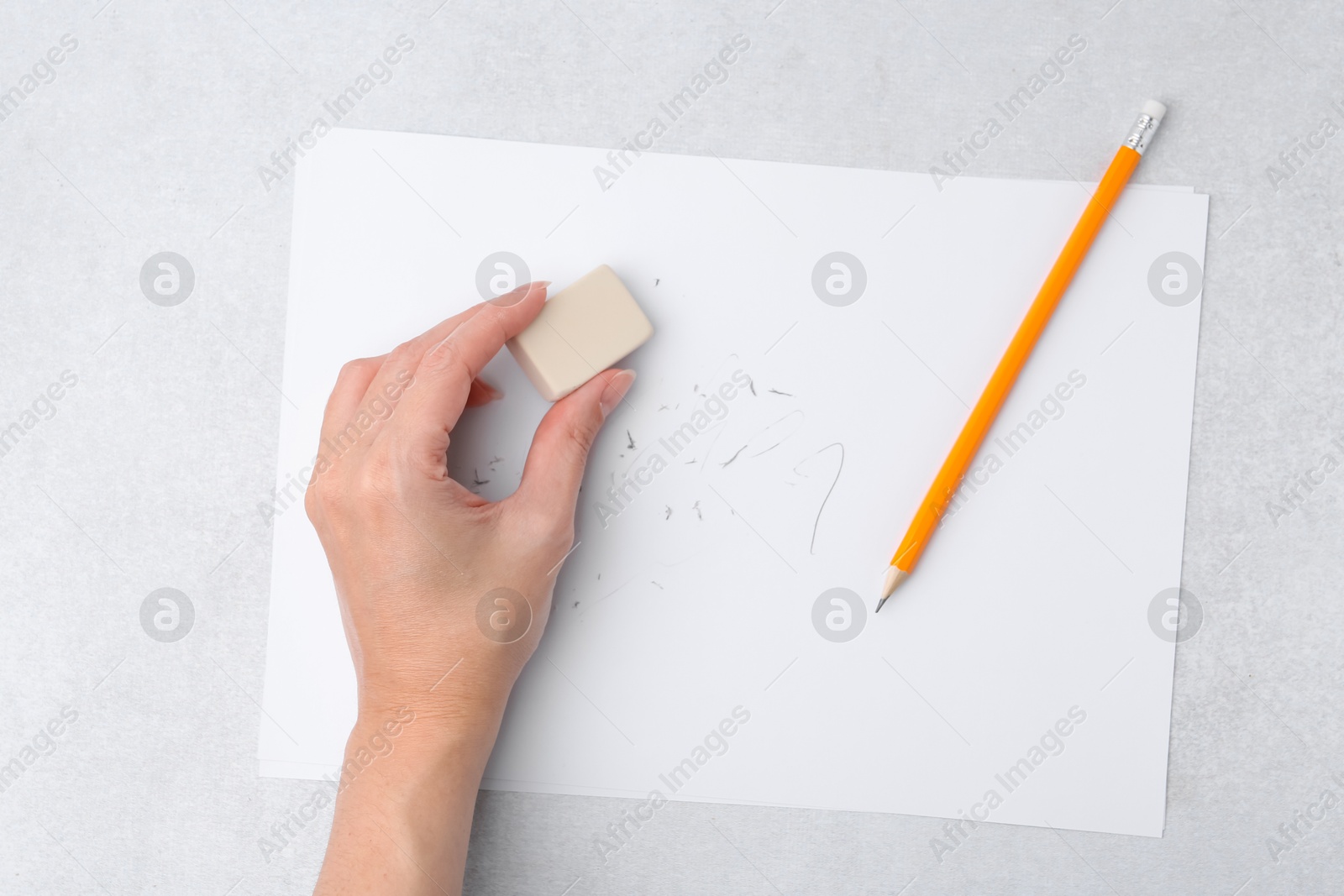 Woman with graphite pencil, eraser and paper sheet at light table, top view Photo of Woman with graphite pencil, eraser and paper sheet at light table, top view
