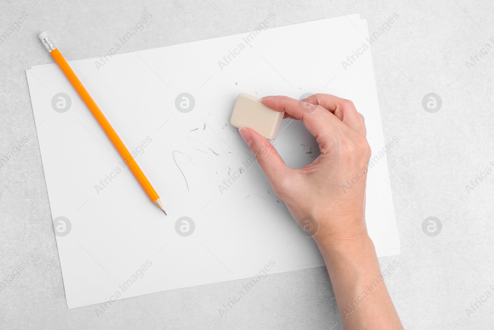 Woman with graphite pencil, eraser and paper sheet at light table, top view Photo of Woman with graphite pencil, eraser and paper sheet at light table, top view