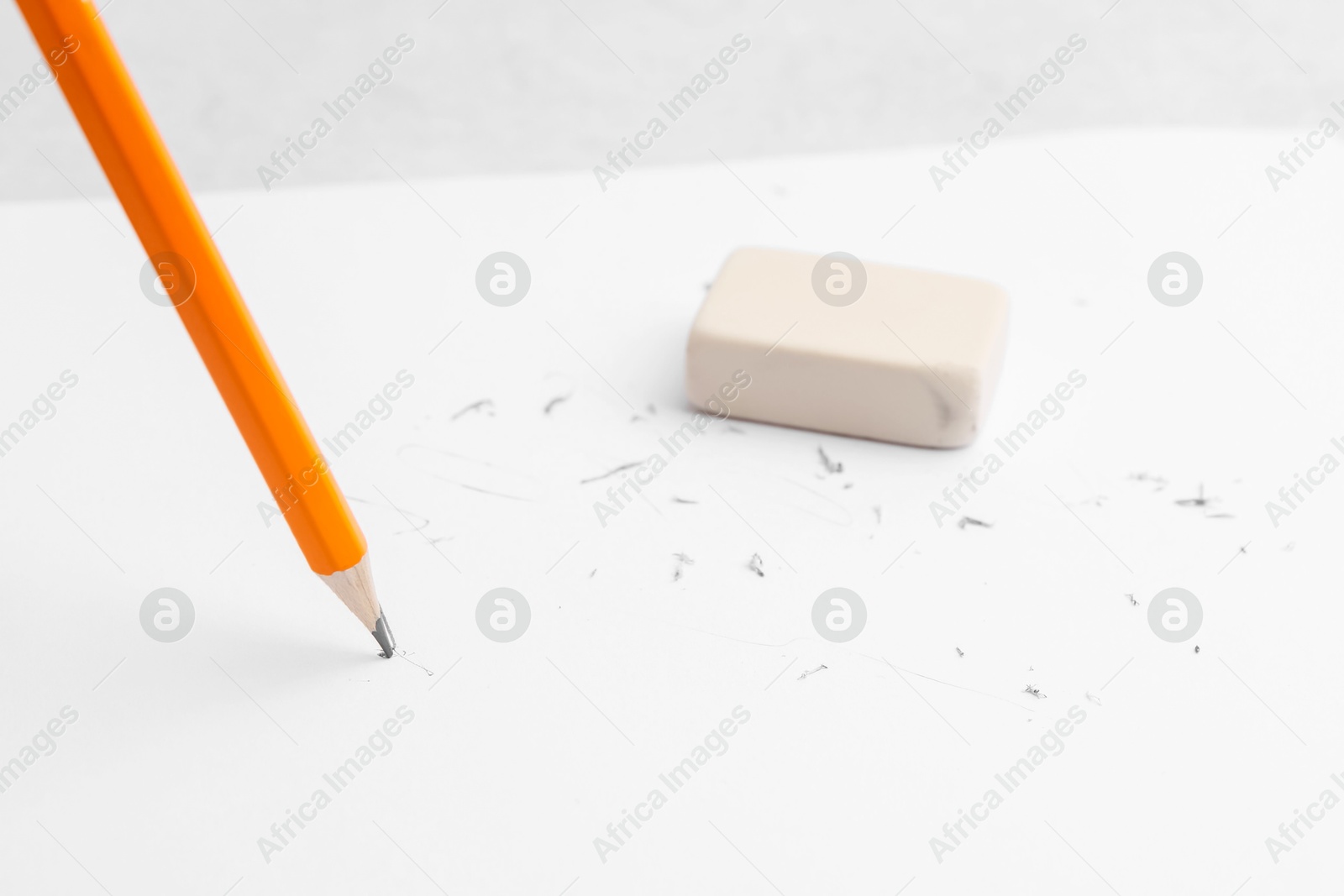 Graphite pencil and eraser on paper sheet, closeup Photo of Graphite pencil and eraser on paper sheet, closeup