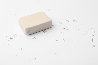 Photo of Eraser on paper sheet with pencil strokes, closeup