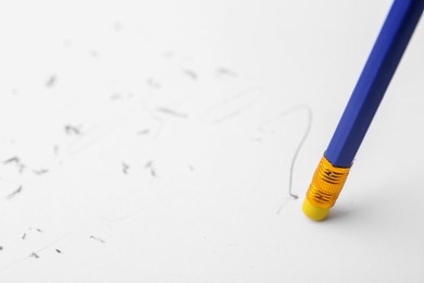 Photo of Graphite pencil with eraser on paper sheet, closeup