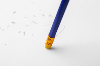 Photo of Graphite pencil with eraser on paper sheet, closeup