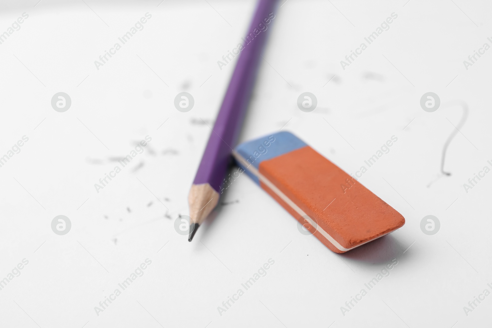 Graphite pencil and eraser on paper sheet, closeup Photo of Graphite pencil and eraser on paper sheet, closeup