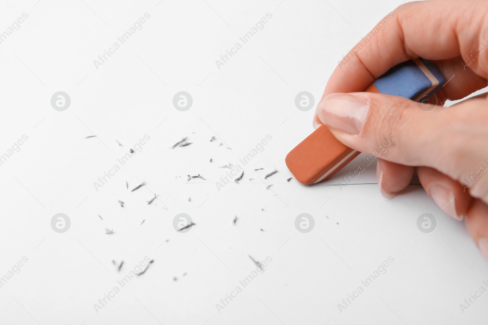 Woman erasing pencil strokes from paper sheet, closeup Photo of Woman erasing pencil strokes from paper sheet, closeup
