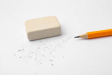 Photo of Graphite pencil and eraser on paper sheet, closeup