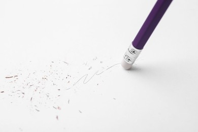 Photo of Graphite pencil with eraser on paper sheet, closeup