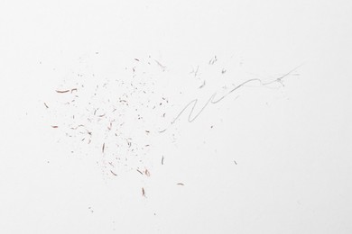 Photo of Graphite pencil strokes and eraser shavings on paper sheet, top view
