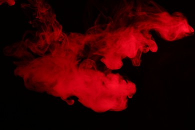 Photo of Hookah smoke in red light on black background, closeup