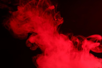 Photo of Hookah smoke in red light on black background, closeup
