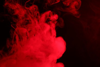 Photo of Hookah smoke in red light on black background, closeup