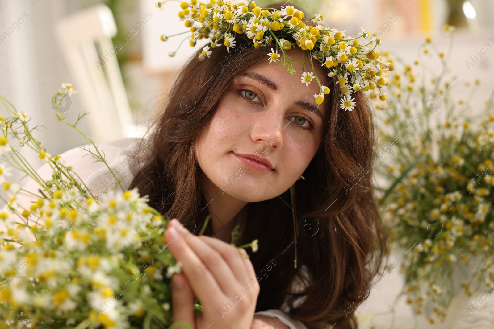 Portrait of beautiful woman with chamomile flowers indoors Photo of Portrait of beautiful woman with chamomile flowers indoors