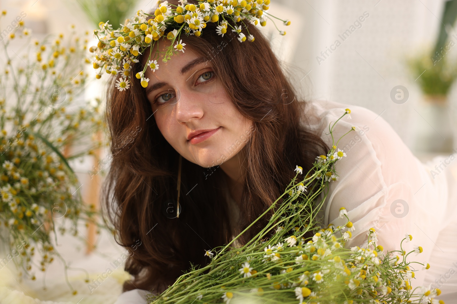 Portrait of beautiful woman with chamomile flowers indoors Photo of Portrait of beautiful woman with chamomile flowers indoors