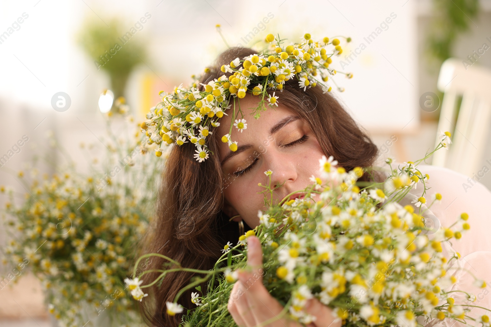 Portrait of beautiful woman with chamomile flowers indoors Photo of Portrait of beautiful woman with chamomile flowers indoors