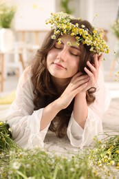 Photo of Beautiful woman with chamomile flowers on floor indoors