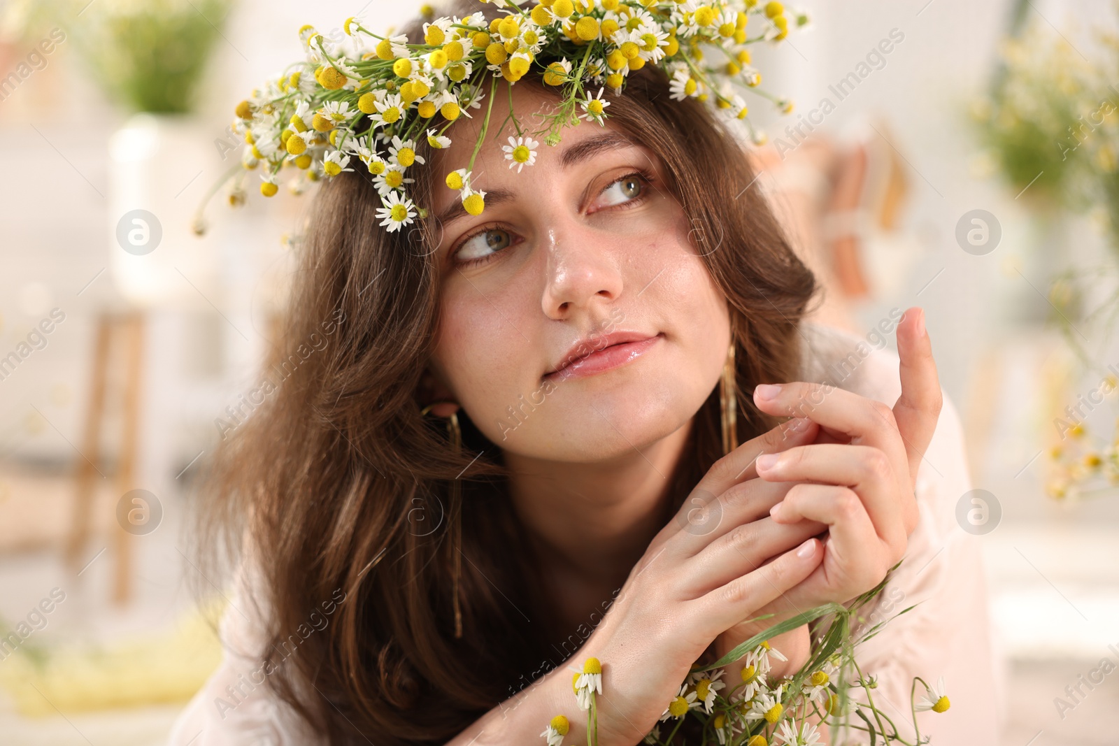 Portrait of beautiful woman with chamomile flowers indoors Photo of Portrait of beautiful woman with chamomile flowers indoors