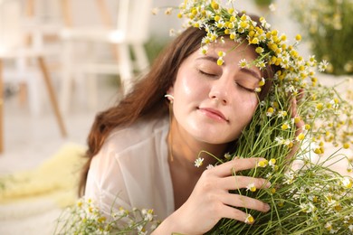 Photo of Portrait of beautiful woman with chamomile flowers indoors