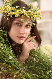 Photo of Portrait of beautiful woman with chamomile flowers indoors