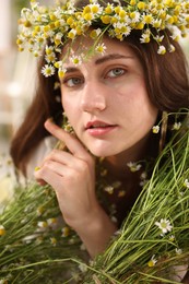 Photo of Portrait of beautiful woman with chamomile flowers indoors