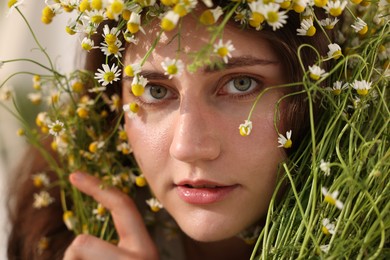 Photo of Portrait of beautiful woman with chamomile flowers, closeup