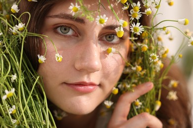 Photo of Portrait of beautiful woman with chamomile flowers, closeup