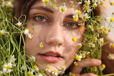 Photo of Portrait of beautiful woman with chamomile flowers, closeup