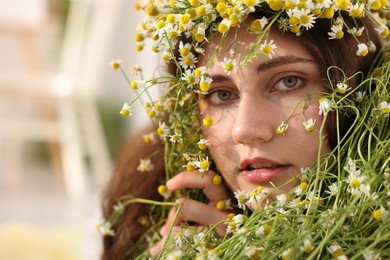 Photo of Portrait of beautiful woman with chamomile flowers indoors