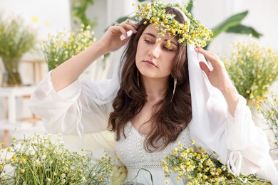 Photo of Portrait of beautiful woman with chamomile flowers indoors