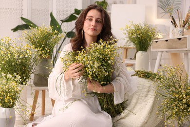 Photo of Portrait of beautiful woman with chamomile flowers indoors